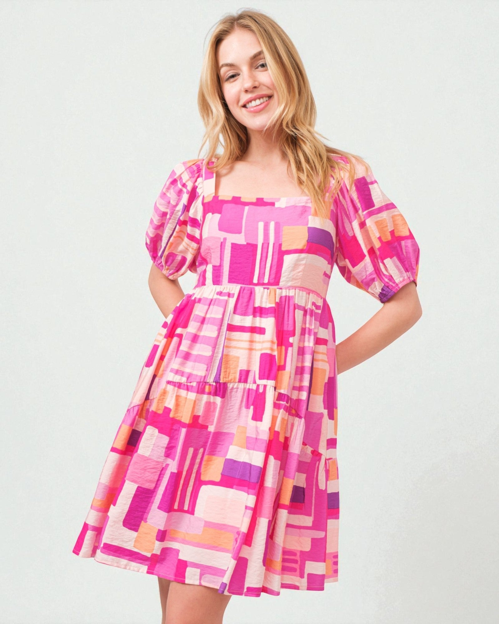 Woman wearing a colorful geometric patterned dress on a white background
