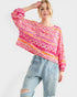 Woman wearing a colorful patterned top and jeans on a white background