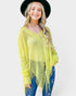 Woman wearing a yellow fringe sweater and black hat on a white background