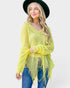 Woman wearing a bright yellow sweater with frayed edges and a black hat on a white background