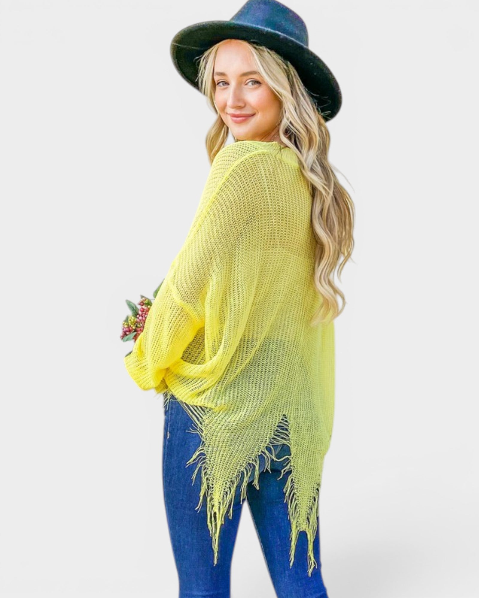 Woman wearing a bright yellow shawl and blue hat on a white background
