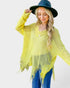 Woman wearing a yellow fringe poncho and blue hat on a white background