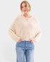 Woman wearing a beige sweater and blue jeans on a white background