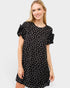 Woman wearing a black dress with white polka dots on a white background