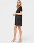 Woman wearing a black dress with white polka dots on a white background