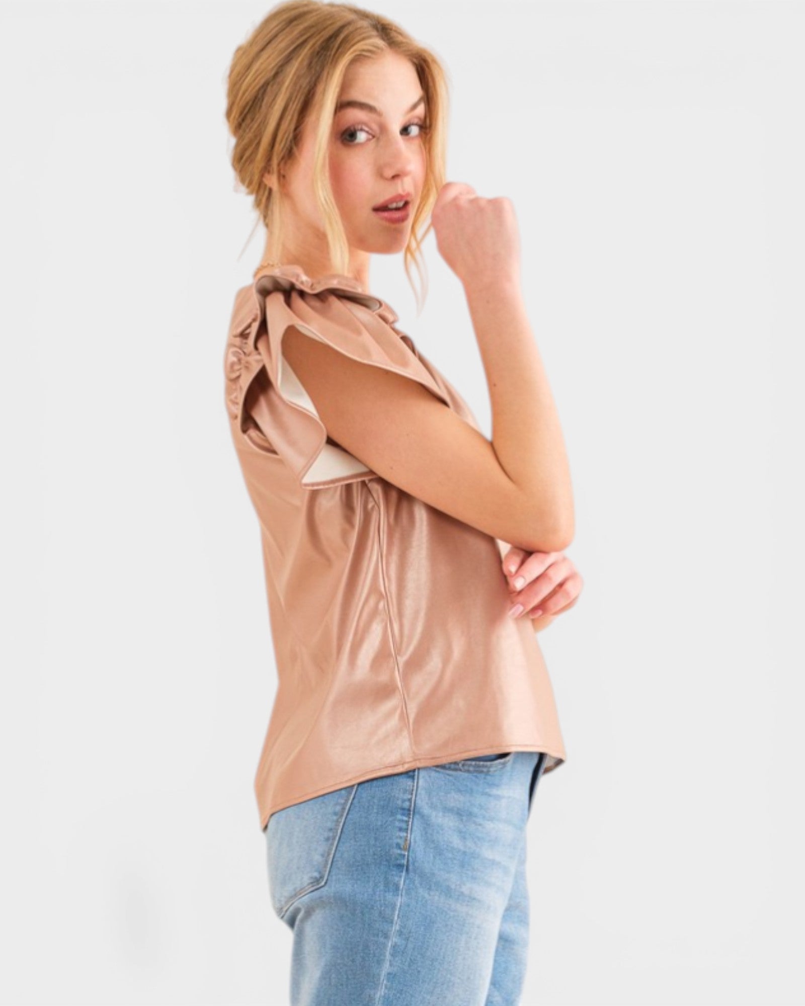 Woman wearing a beige top and blue jeans on a white background