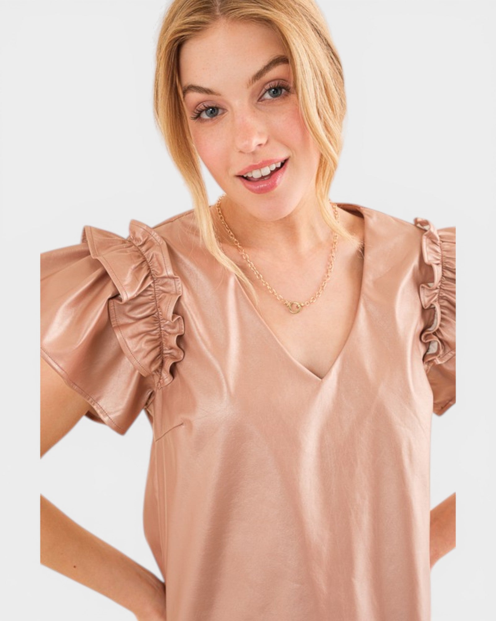 Woman wearing a beige blouse with ruffled sleeves on a light background