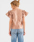 Woman wearing a rose gold blouse with ruffled sleeves on a white background