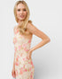 Woman wearing a floral dress against a plain background