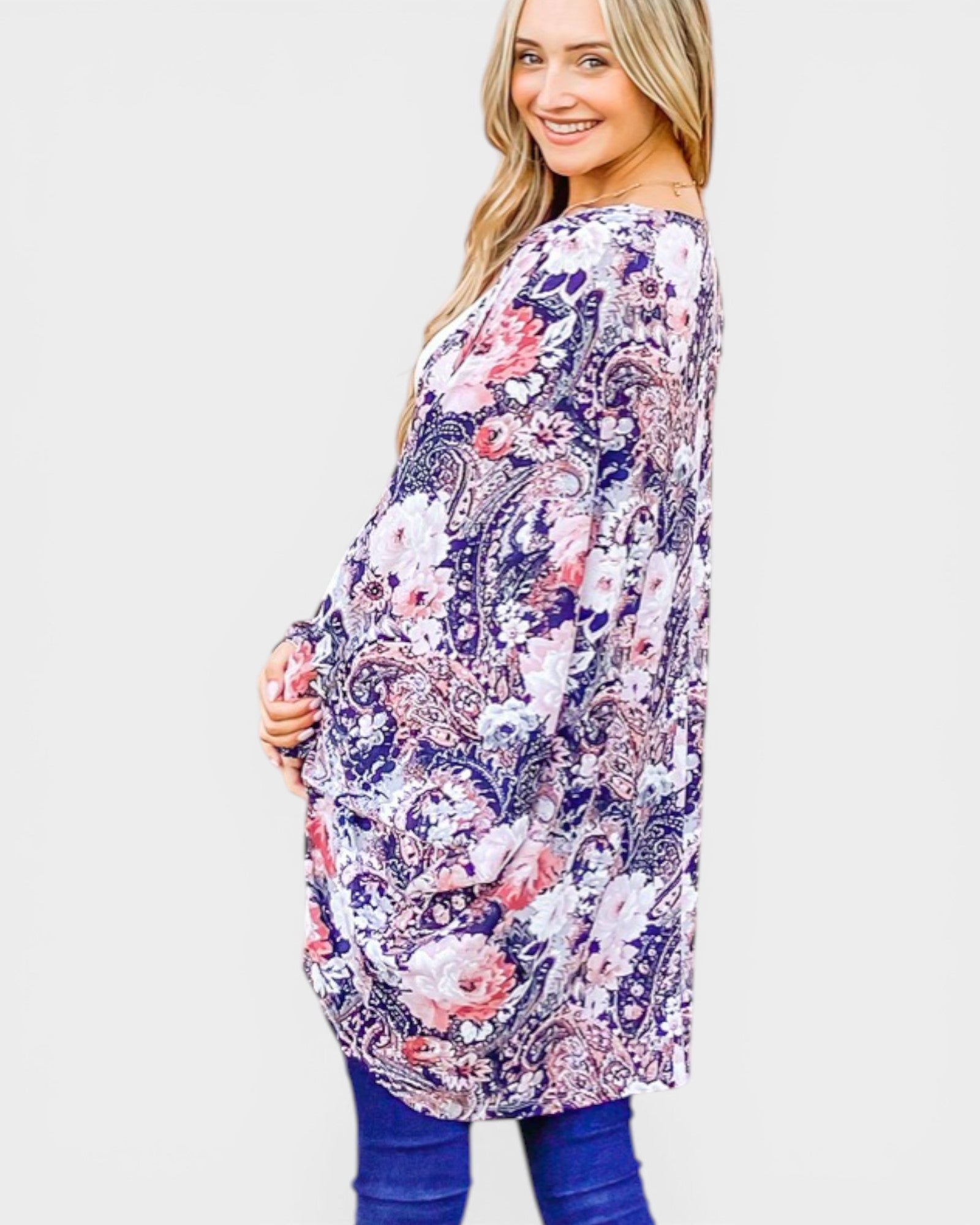 Woman wearing a floral and paisley patterned dress on a white background