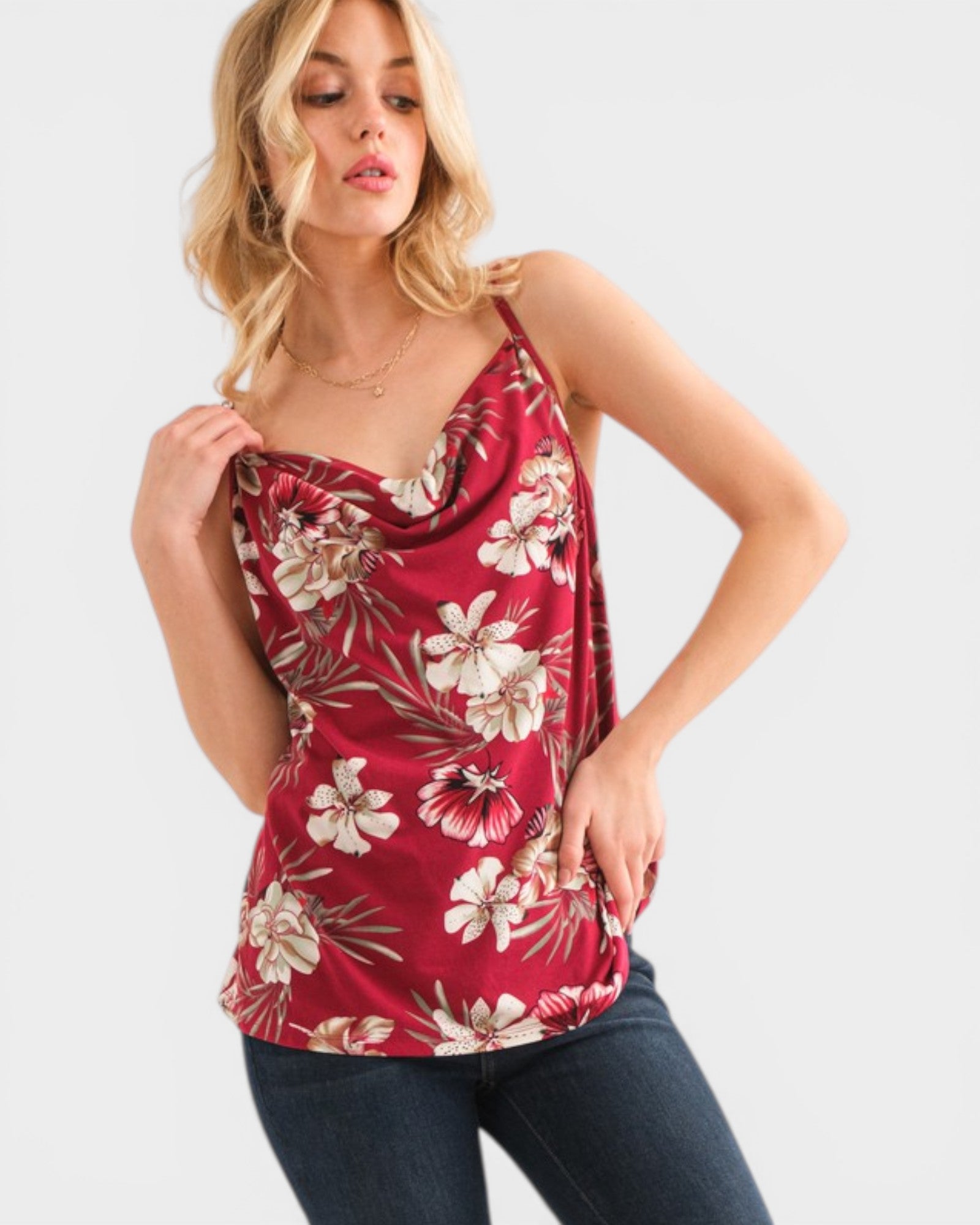 Woman wearing a red floral sleeveless top on a white background