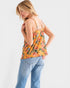 Woman wearing a floral tank top and jeans on a white background