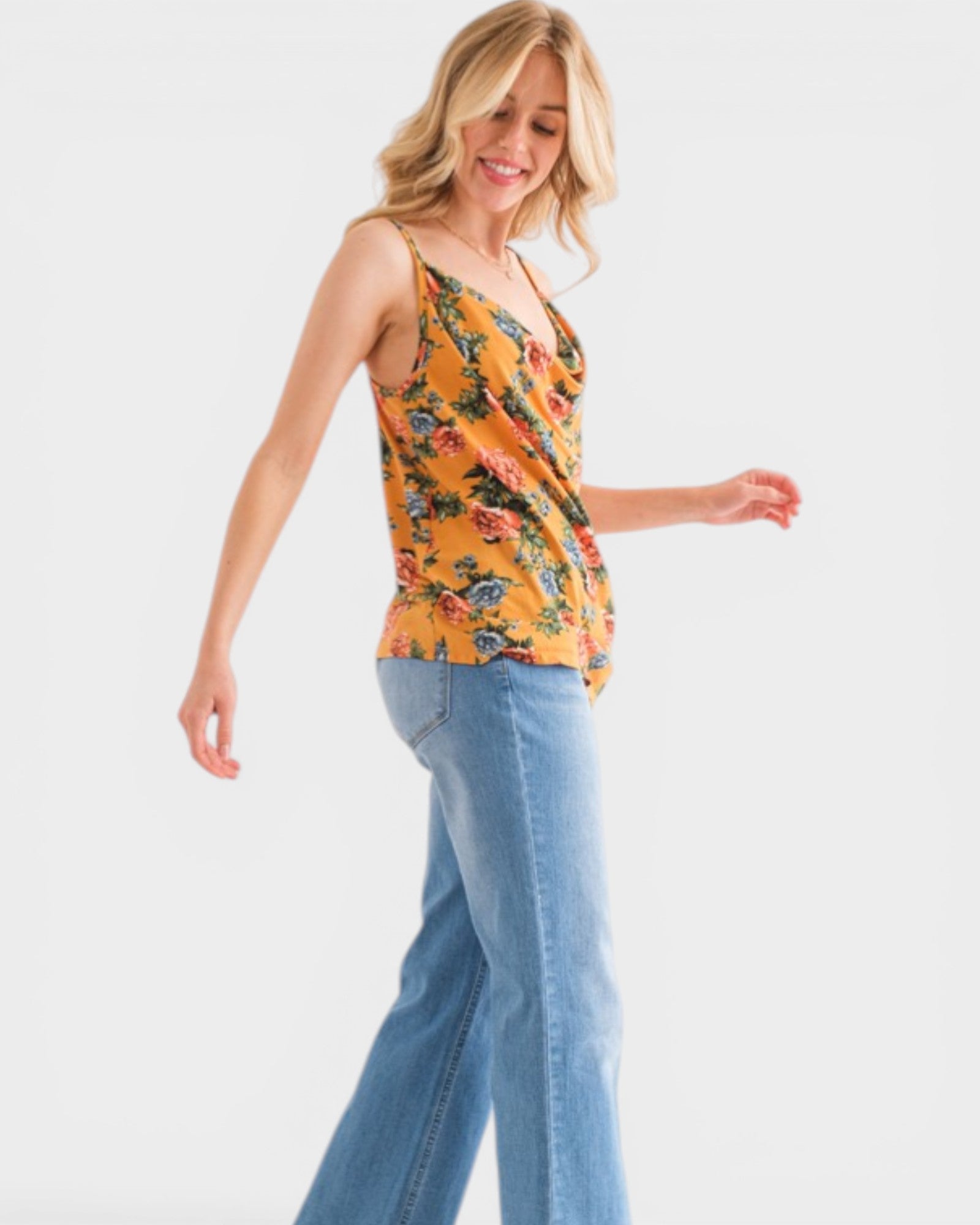 Woman wearing a floral top and jeans on a white background