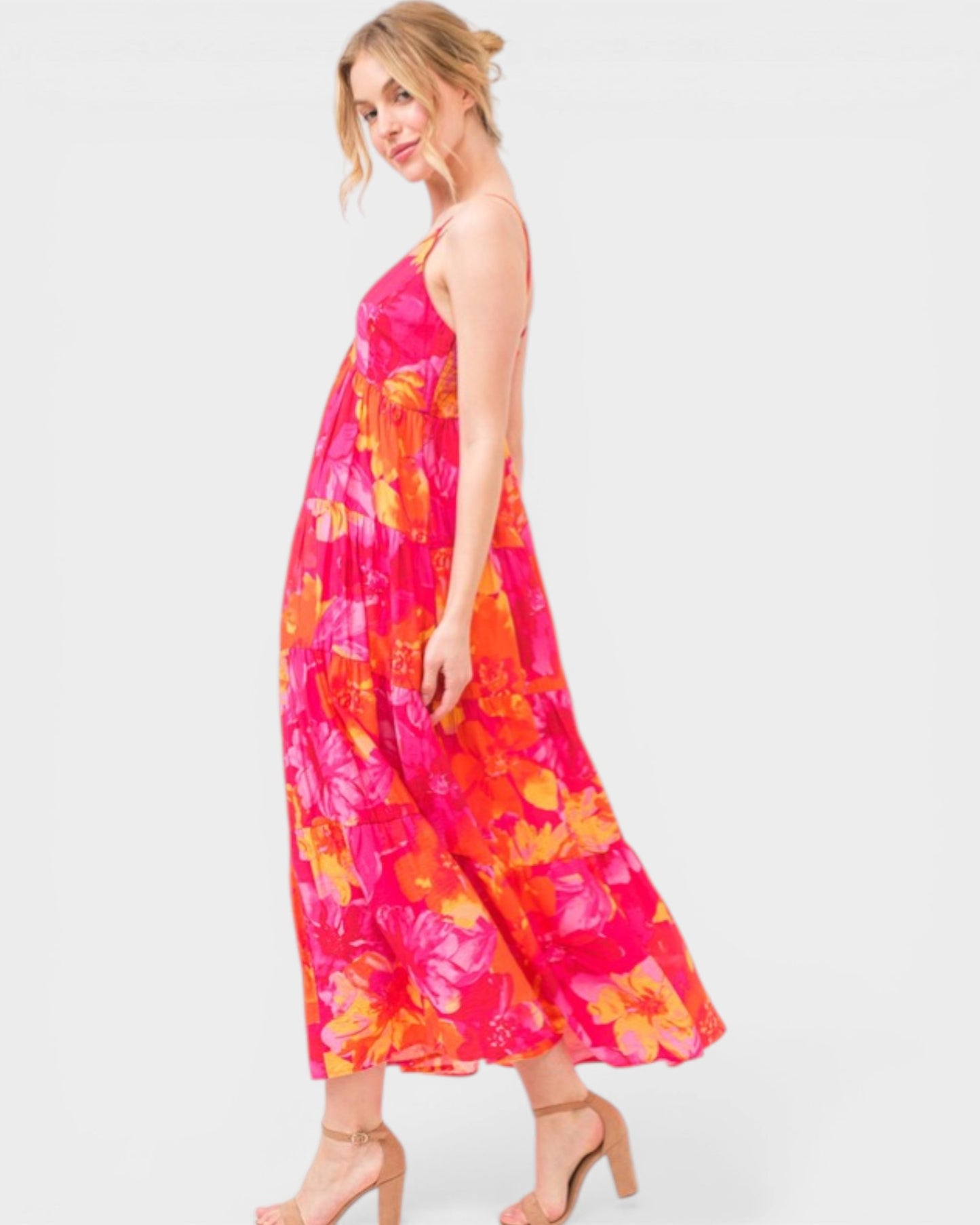 Woman wearing a vibrant floral dress on a white background