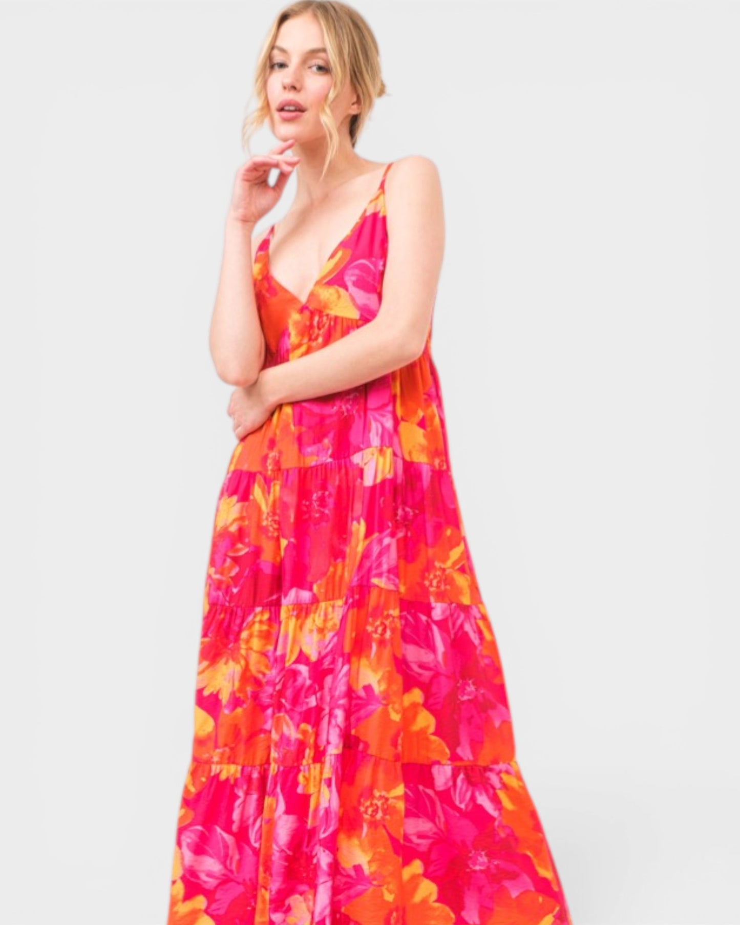 Woman wearing a vibrant floral dress on a white background