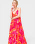 Woman wearing a vibrant floral dress on a white background