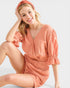Woman wearing a peach-colored dress with a matching headband on a white background
