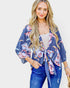 Woman wearing a blue floral kimono with a plain background