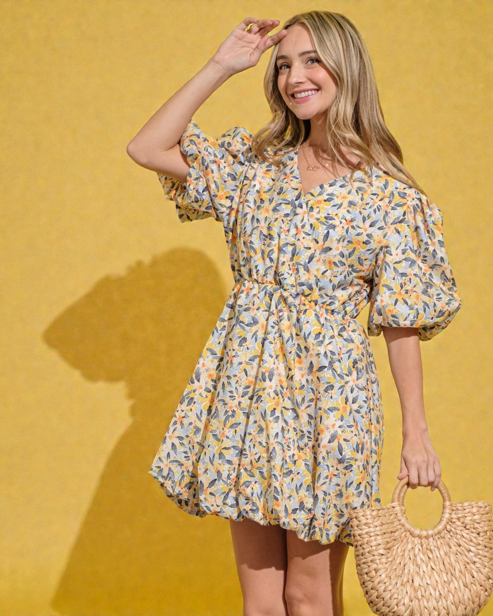 Woman wearing a floral dress against a yellow background