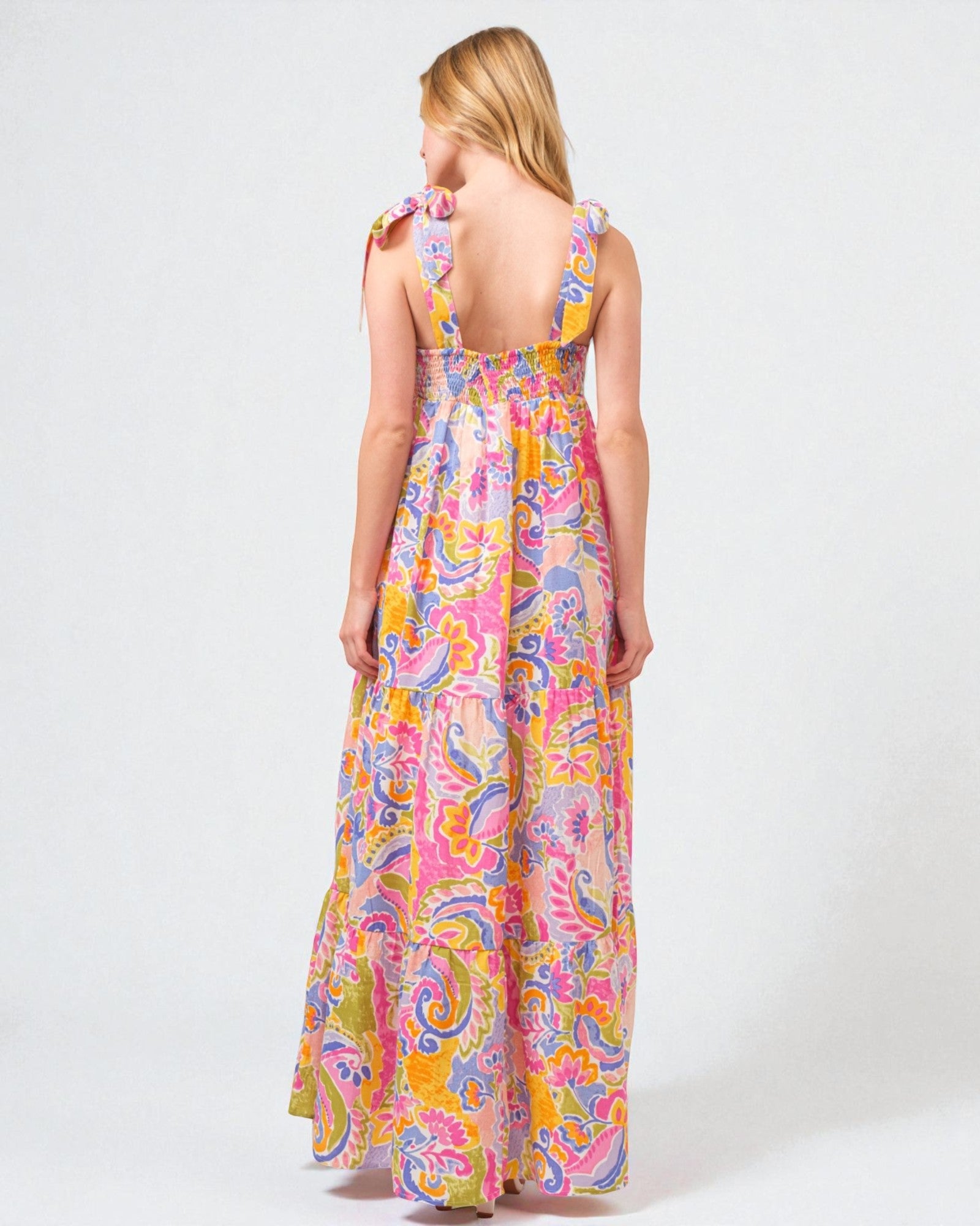 Woman wearing a colorful paisley dress on a white background