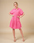 Woman wearing a pink dress against a beige background