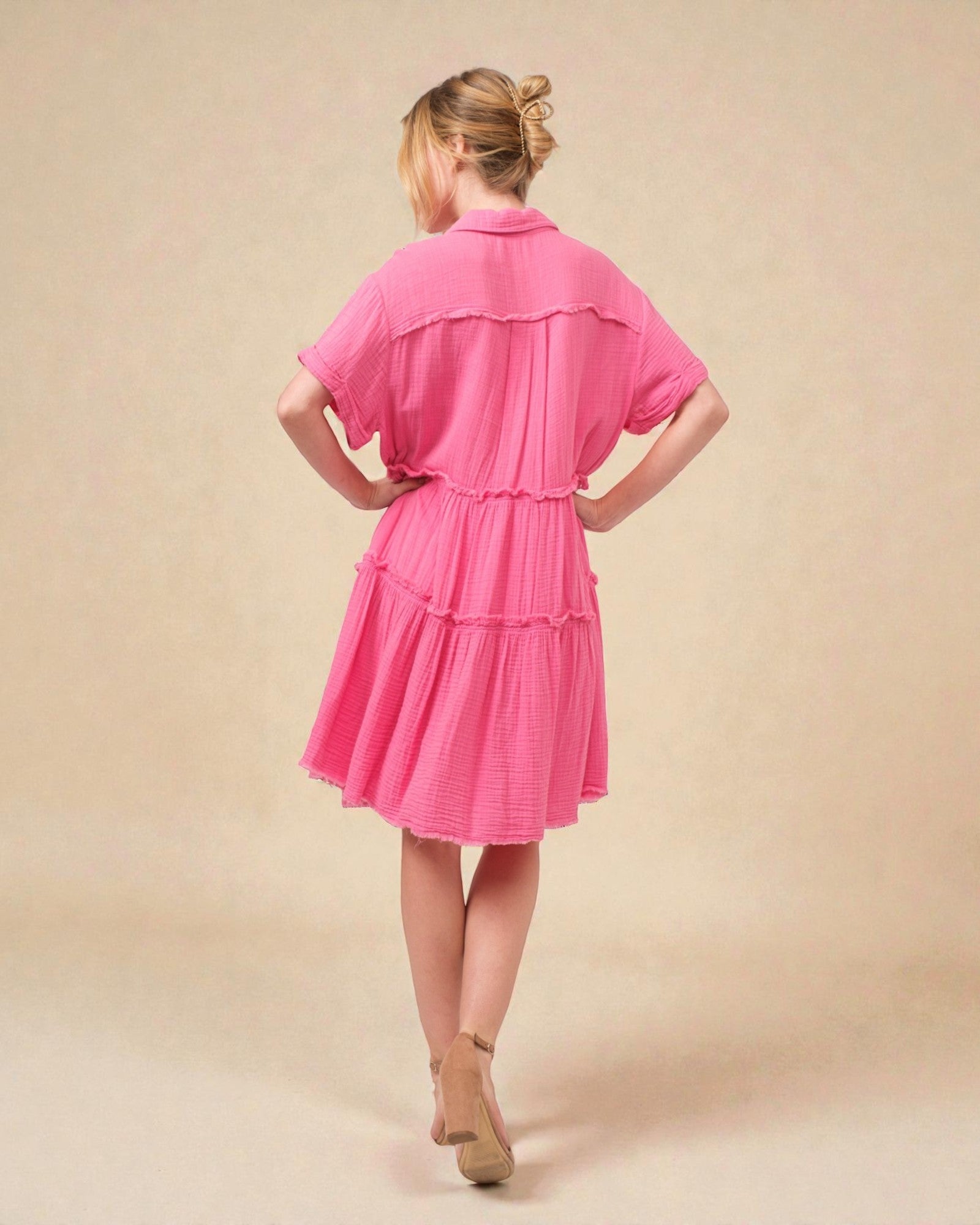 Woman wearing a pink dress against a beige background