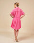 Woman wearing a pink dress against a beige background