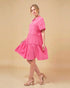 Woman wearing a pink dress against a beige background