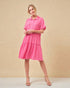 Woman wearing a pink dress against a beige background