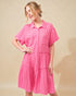 Woman wearing a pink dress against a beige background