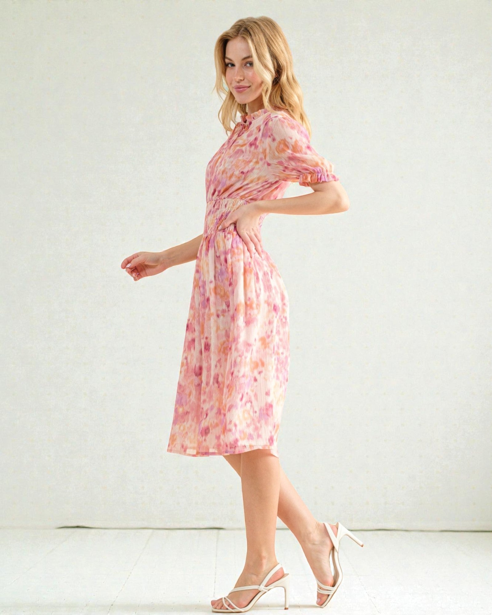 Woman wearing a pink floral dress against a white background