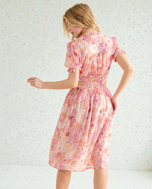 Woman wearing a pink floral dress against a white background