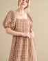 Woman wearing a textured pink dress against a beige background