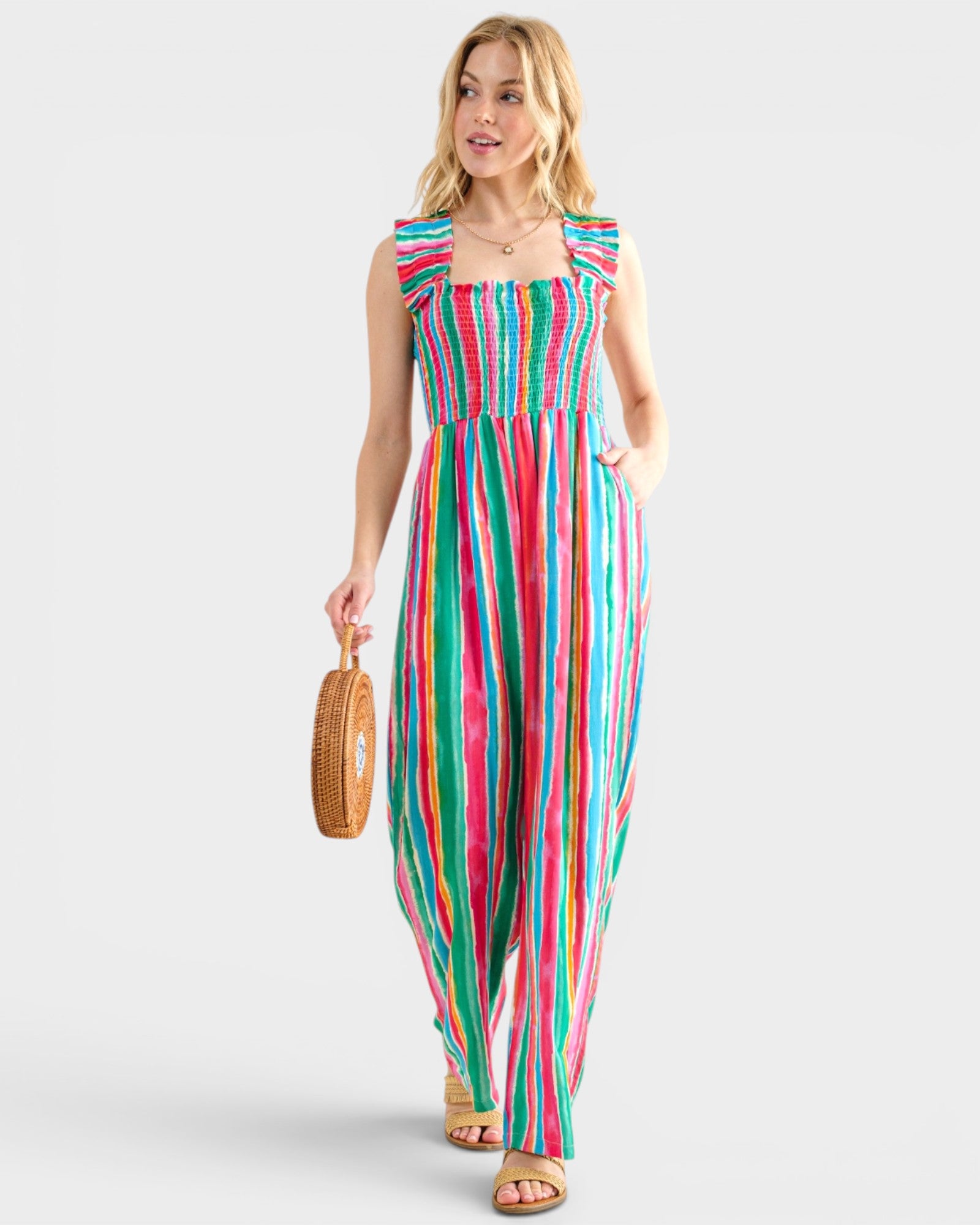 Woman wearing a colorful striped jumpsuit on a white background