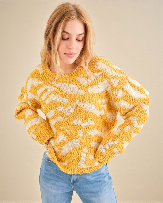 Woman wearing a yellow and white patterned sweater against a beige background