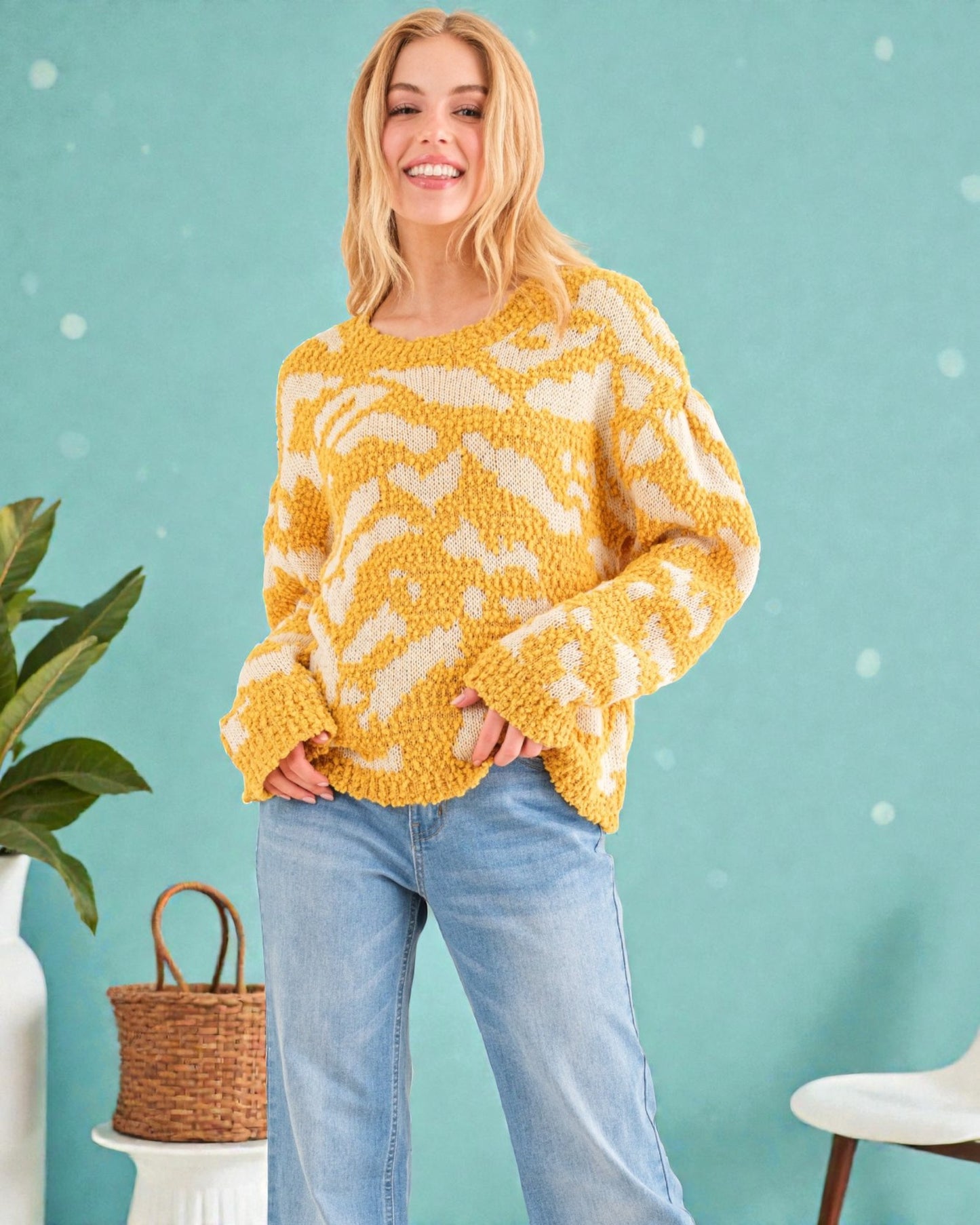 Woman wearing a yellow patterned sweater against a teal background