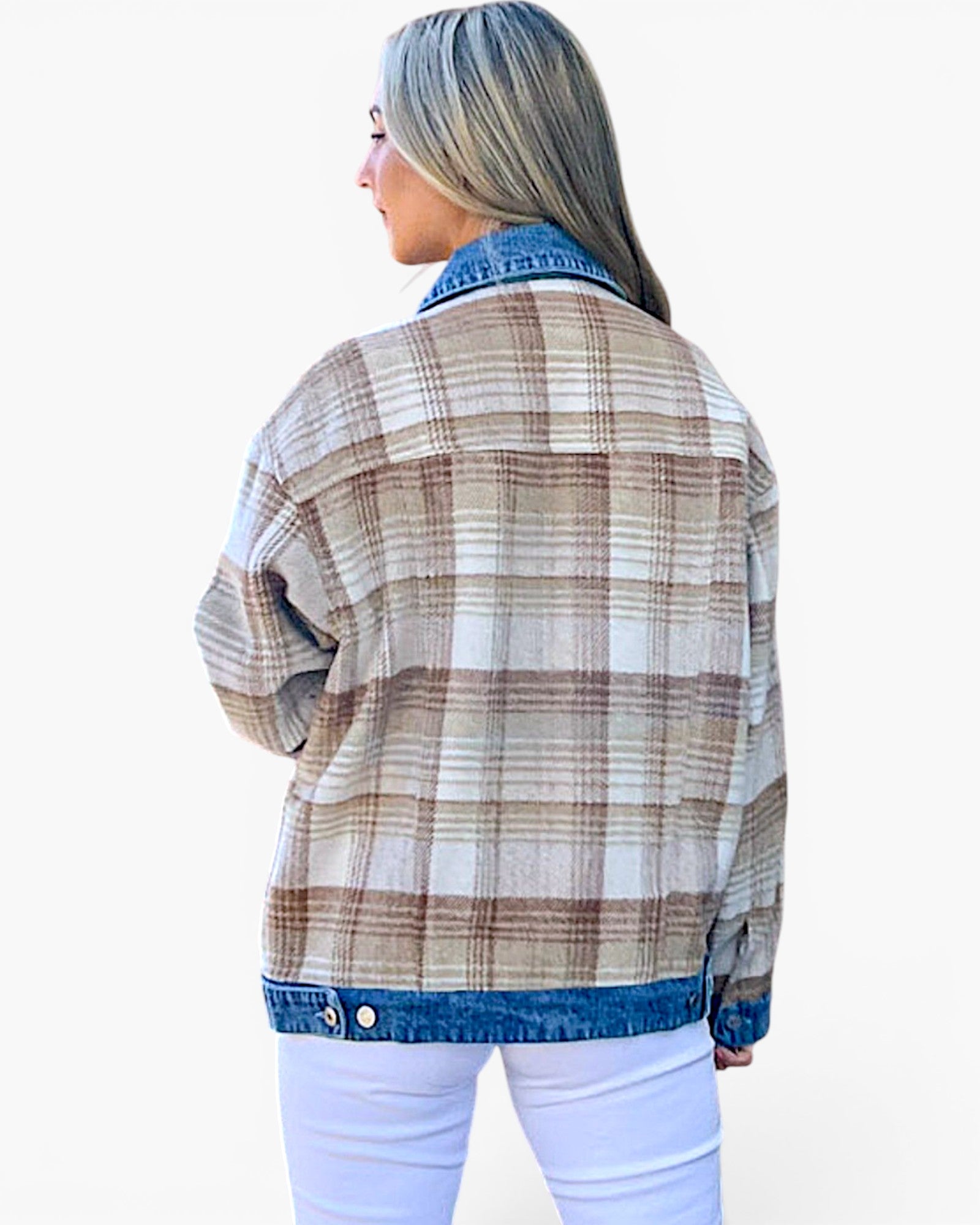 A woman shown from the back wearing a beige and brown plaid flannel jacket with a blue denim collar, hem, and cuffs, paired with white pants, against a plain white background.