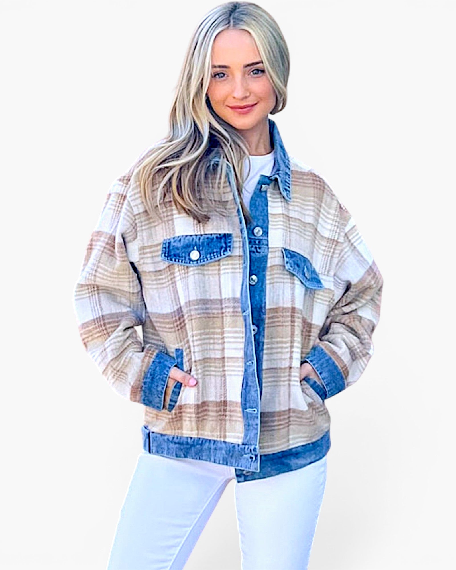 A woman modeling a plaid button-up shirt jacket with blue denim trim, featuring a beige, brown, and white plaid pattern with blue denim collar, cuffs, hem, and chest pockets, paired with white pants against a light gray background.