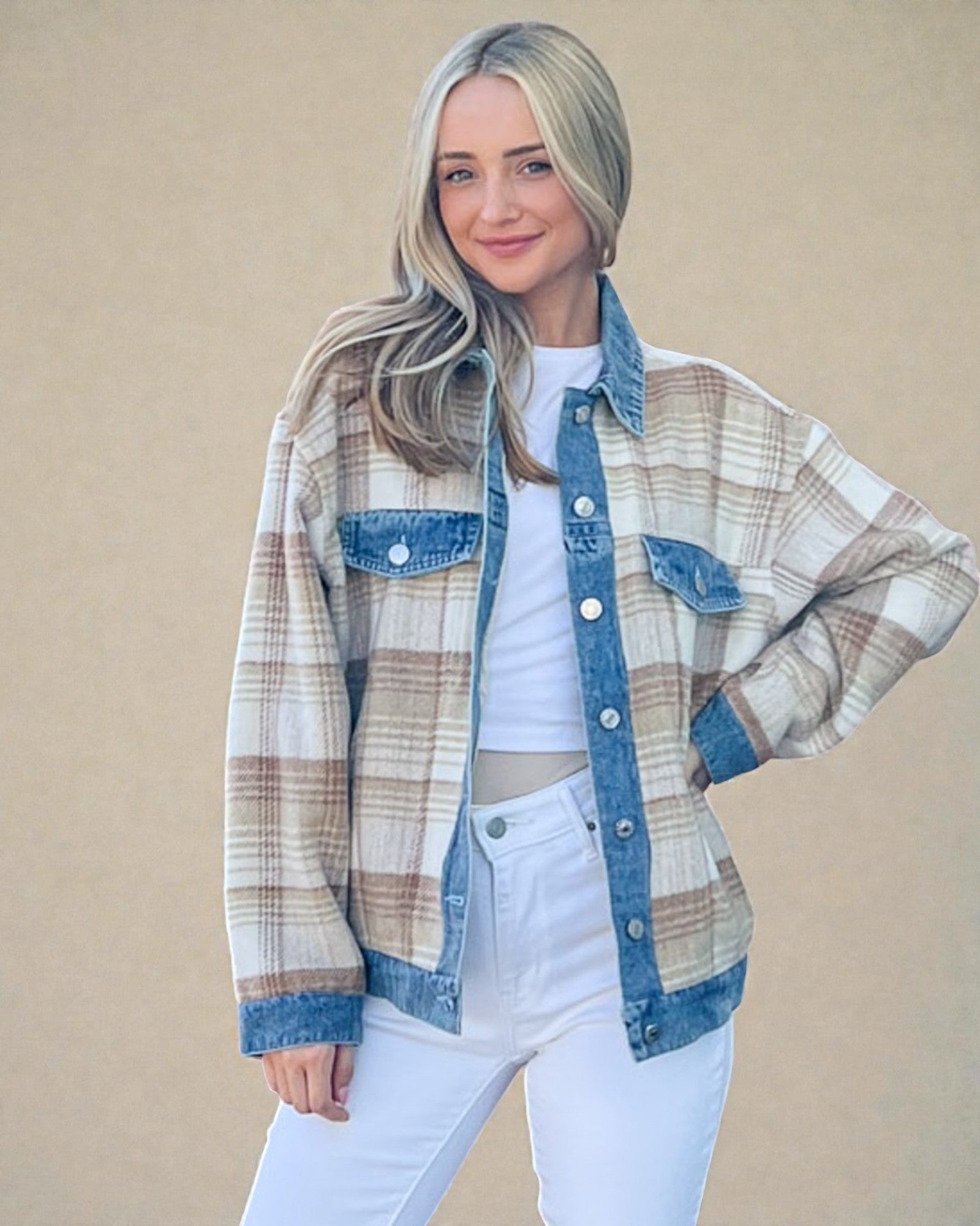 Woman wearing a plaid shirt over a white top and jeans on a beige background