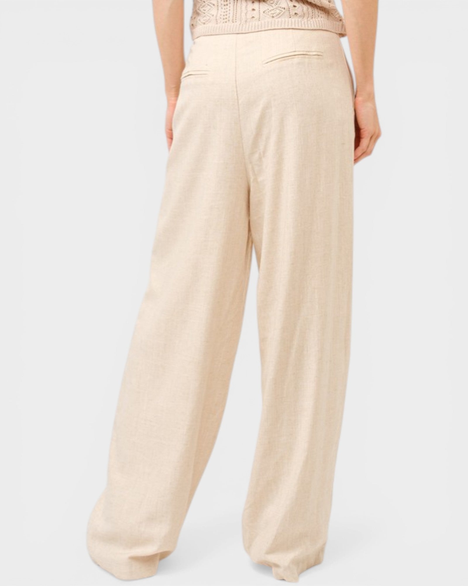 Beige wide-leg pants worn by a person on a light gray background