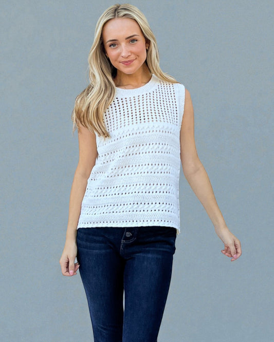 Woman wearing a light blue sleeveless crochet top against a gray background