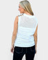 Woman wearing a white sleeveless crochet top with button details on a plain background