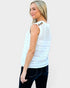 Woman wearing a light blue sleeveless crochet top on a plain background