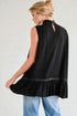 Woman wearing a black sleeveless top with a ruffled hem on a plain background
