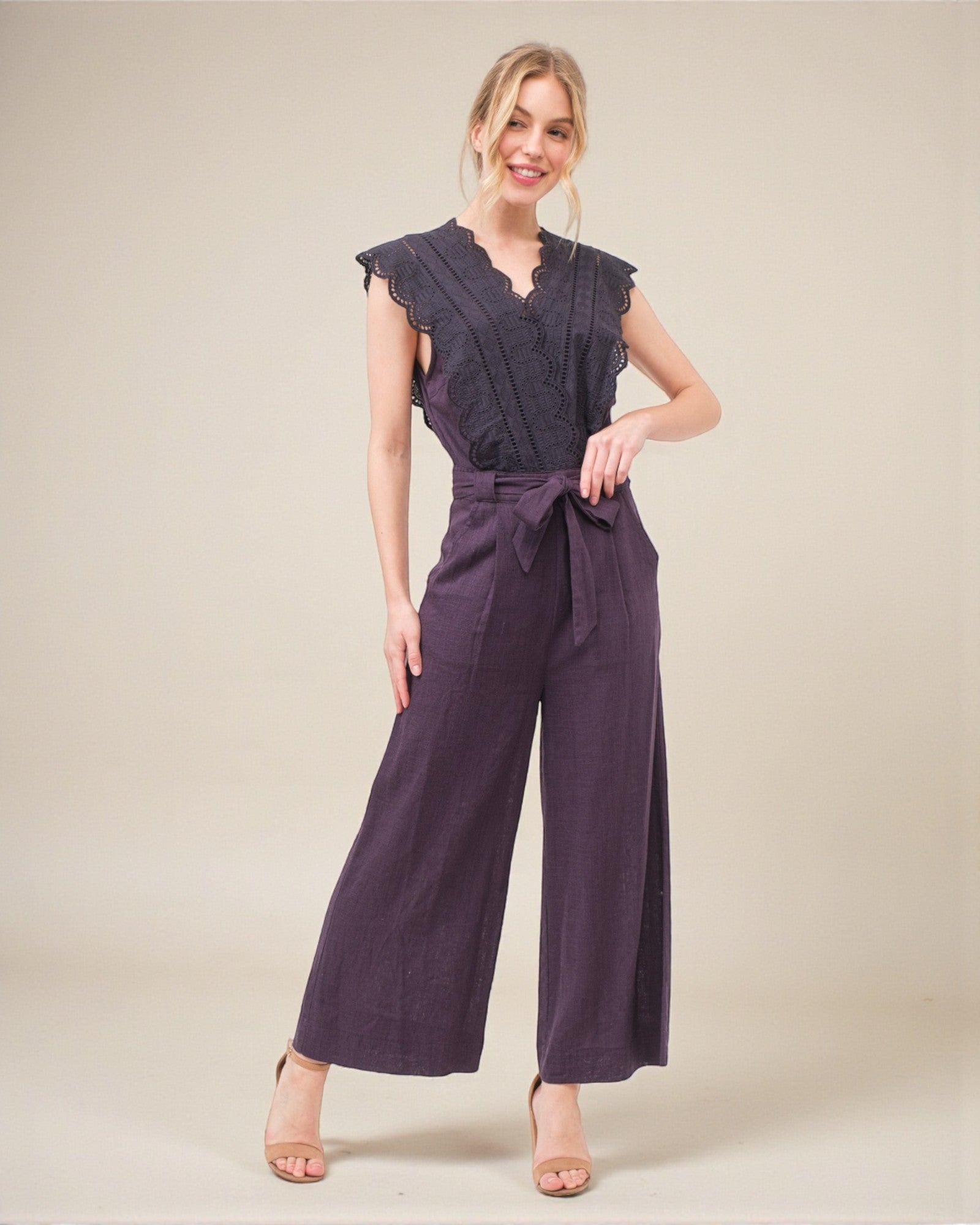 Woman wearing a purple jumpsuit on a plain background