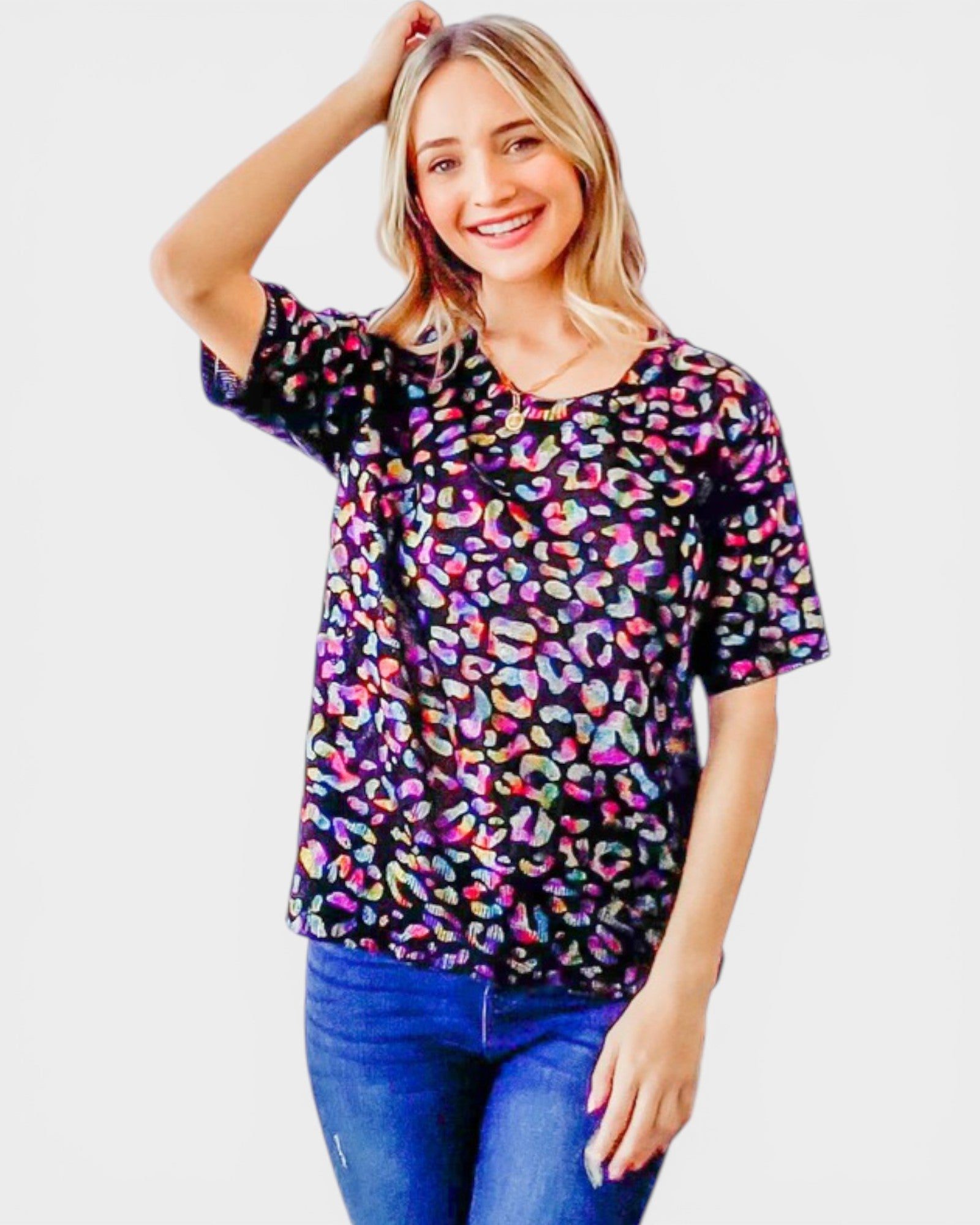 Woman wearing a colorful leopard print top on a white background