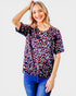Woman wearing a colorful leopard print top on a white background