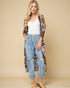 Woman wearing a long leopard print cardigan over a white top and jeans on a beige background
