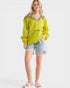 Woman wearing a yellow jacket with leopard print accents on a white background