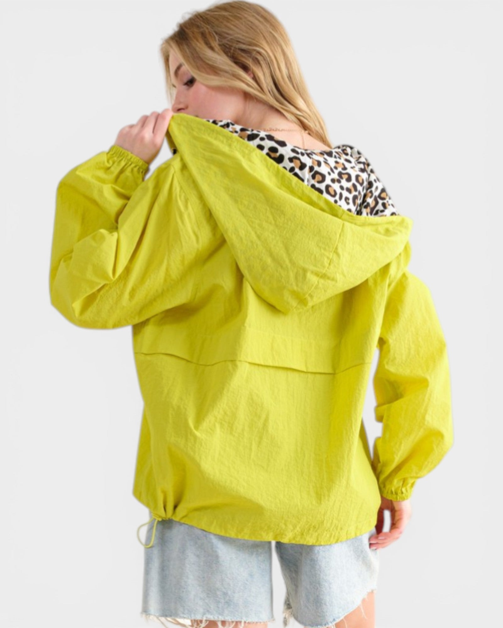 Woman wearing a bright yellow raincoat on a white background